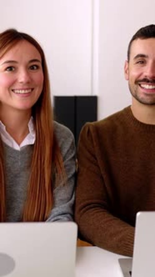 Cheerful Portrait of Young Businesspeople Using a Laptop in an Office