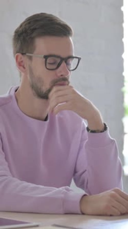 Young Man Thinking While Sitting in Office, Vertical Video
