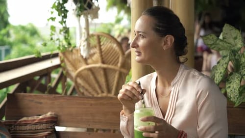 Woman Drinking Cocktail Sitting In Cafe