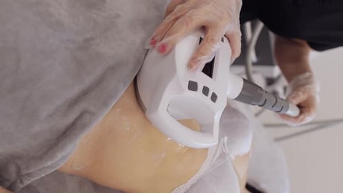 Doctor Makes Woman Cavitation LPG Vacuum Roller Massage on Belly Correction Figures in Spa Clinic