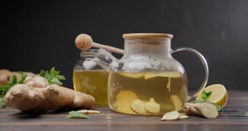 Steaming Glass Kettle with Organic Herbal Tea with Ginger and Lemon
