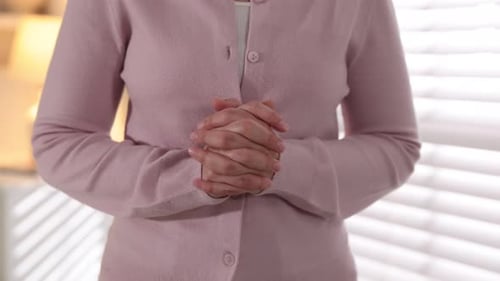 Woman cracking her knuckles at home, closeup