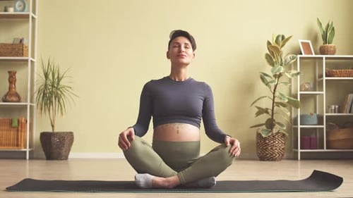 Pregnant Woman Meditating Peacefully in Living Room