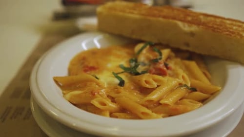 Delicious red pasta bowl with garlic bread on the side -close up