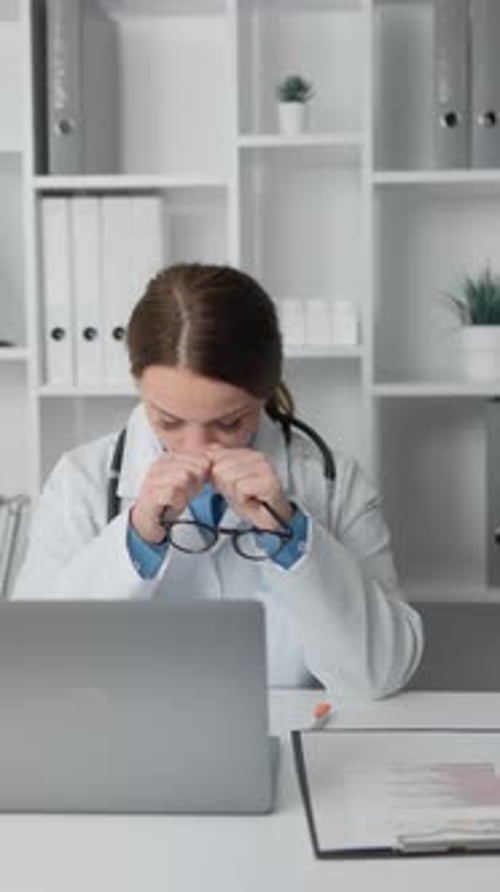 Distressed Woman Doctor at Her Desk in Office