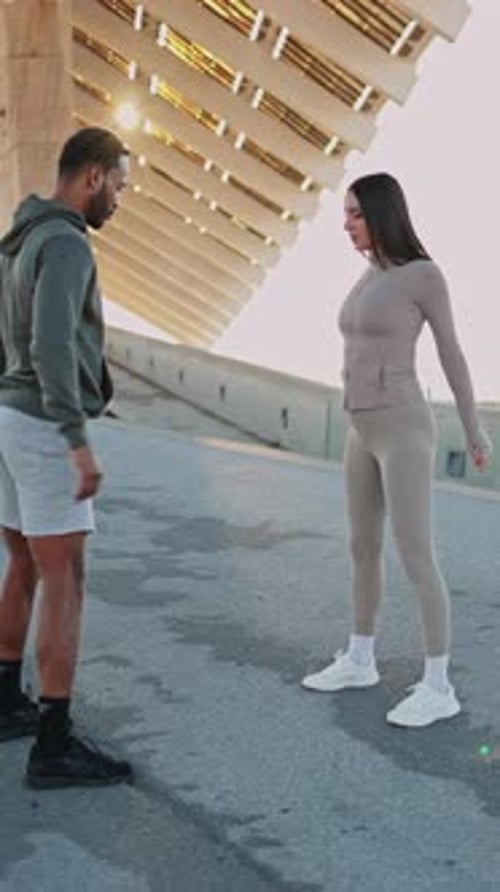 Personal Trainer Guiding Client Through Squats Outdoors