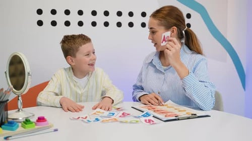 Speech Therapist Working on Articulation with Young Boy