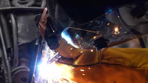 Zeitlupe. Ein Arbeiter verwendet eine Nahaufnahme einer Schweißnaht bei der Arbeit. 4K
