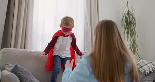 Boy in Superhero Costume Plays with Mother