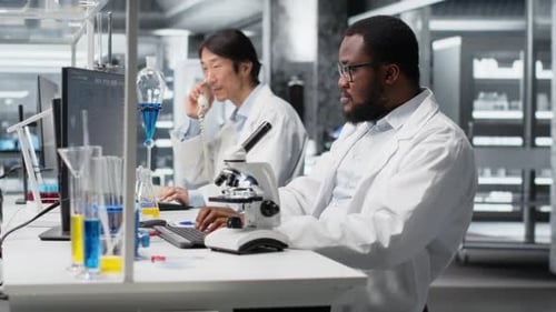 Labormikrobiologe verwendet Mikroskop zur Zellanalyse und schreibt Informationen