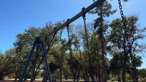 Chains on a swing swinging as the swing swings, in a park in Cape Town.