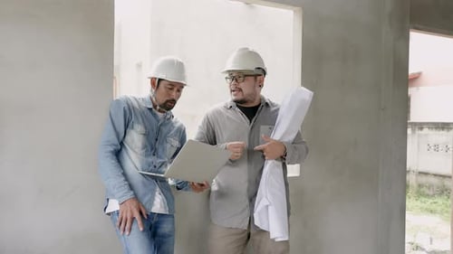 Home designer And the Indian architect has a mustache. standing in a house under construction