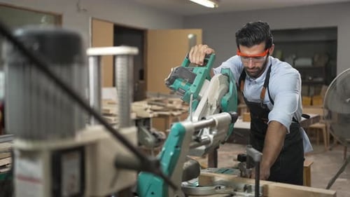 Carpenter is working together at workshop.