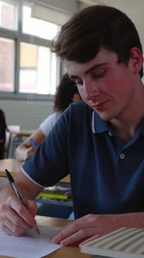 Vertical Video of Young Student Man Doing an Exam at High School Classroom
