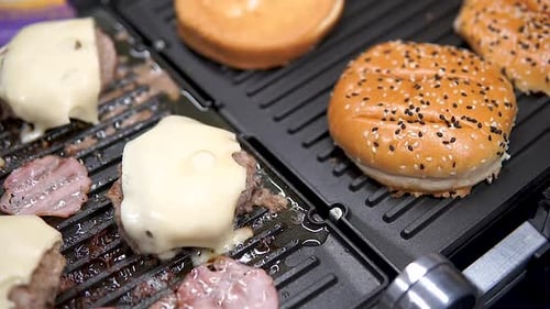 Juicy Cheeseburgers Cooking on a Hot Grill