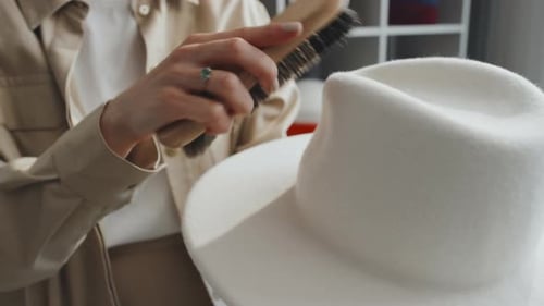 Woman Brushing and Cleaning a White Hat