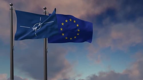 NATO and European Union Flags Waving Against Cloudy Sky
