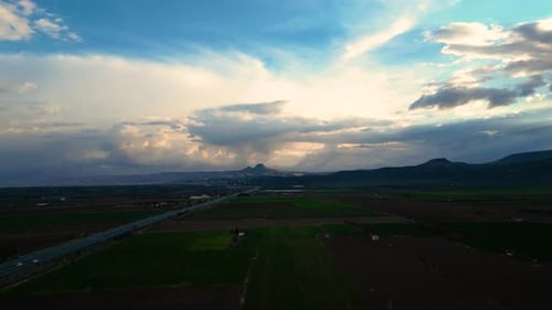 Aerial View of Highway Across Rural Farmlands at Sunset