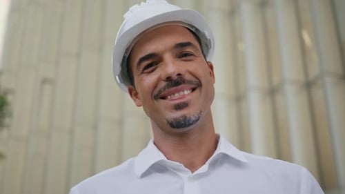Happy Engineer Posing Modern Architecture Portrait Latin Man Taking Off Hardhat