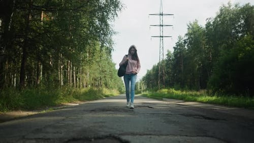 Young Lady Walking Alone Along Forest Road With Power Lines