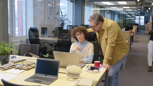 Des collègues enthousiastes discutent de problèmes de travail dans un bureau à aire ouverte