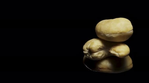 cashew nuts rotate, on a black background close-up. In move