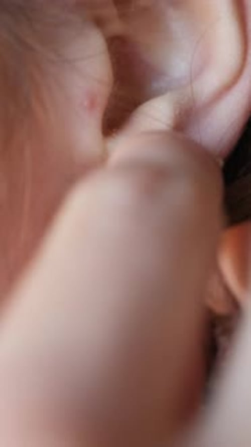 Woman Putting Silver Hoop Earring in Ear