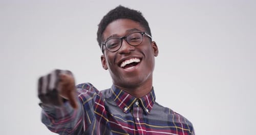 4k video footage of a young man pointing at the camera against a grey background