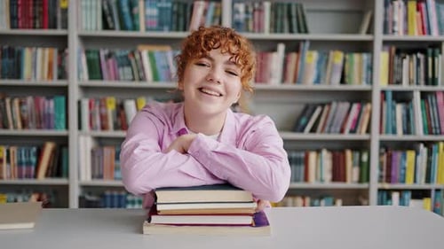 Smiling Student with Books in a Library