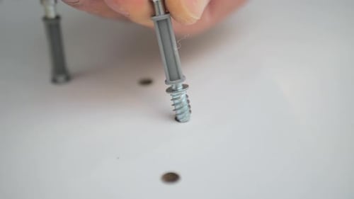 Screws Being Placed Into Holes in Furniture