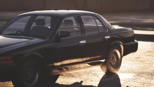 Classic Black Car Parked on a Sunlit Street During the Golden Hour