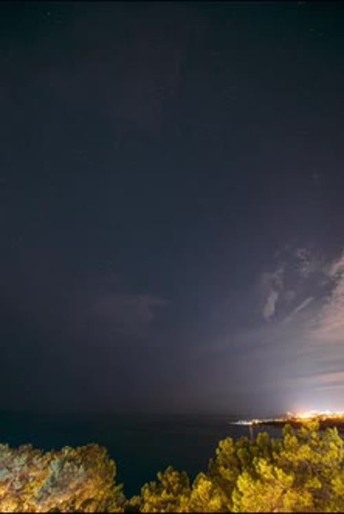 Night Sky Time-Lapse Over City and Ocean