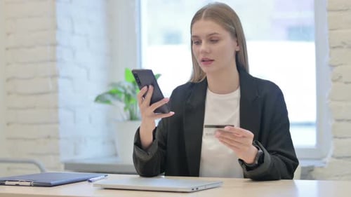 Woman Using Smartphone and Credit Card Indoors