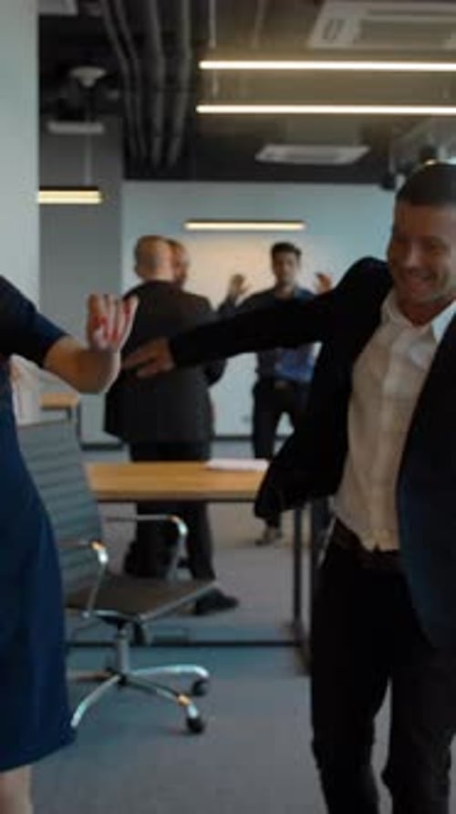 Colleagues Happily Dancing Together in Office