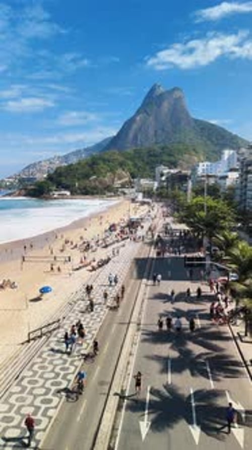Vertical: Drone sobrevoando a movimentada praia do Leblon, no Rio de Janeiro - 60 fps