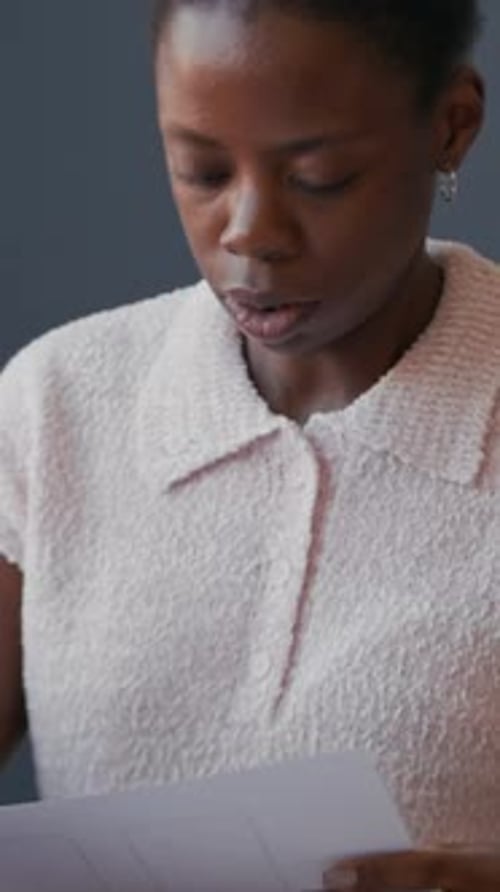 Vertical of Black UX Designer Analyzing Mobile App UI on Paper at Office