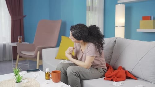 Young Adult Woman Massaging Her Wrist at Home