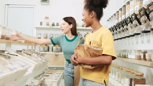 Two young women shopped in refill store, reusable bags, and zero-waste grocery.