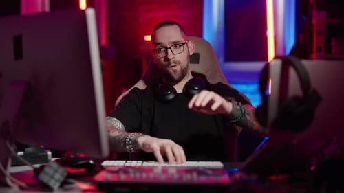 Man Typing on Keyboard in Gaming Room