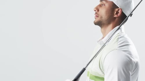 Young biracial man poses with a golf club, with copy space