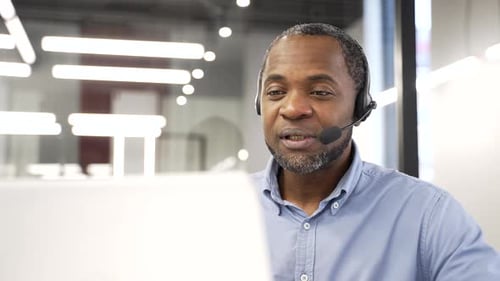 African american male corporate operator who works in customer support speaks on a video call using