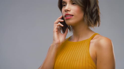 Technology, Communication And People Concept - Happy Laughing Young Woman In Mustard Yellow Top C...