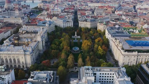 Aerial view of Szabadság Square in central Budapest, framed by historic buildings and autumn trees,