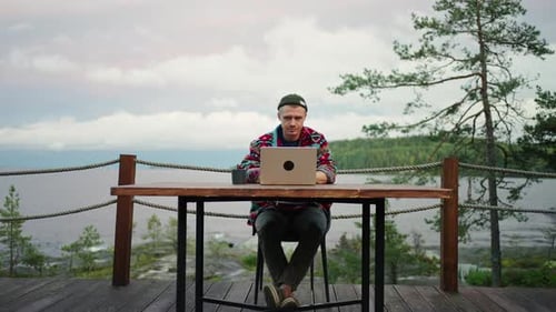 Male Freelancer Working With Laptop On Terrace With View On Beautiful Landscape Zooming Dolly Shot
