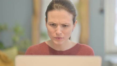 Close Up of Beautiful Woman Reacting to Loss on Laptop