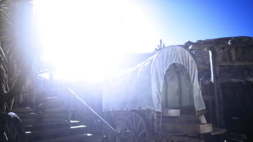 Weathered Wagon with Wooden Wheel Under Desert Sunlight Ambiance