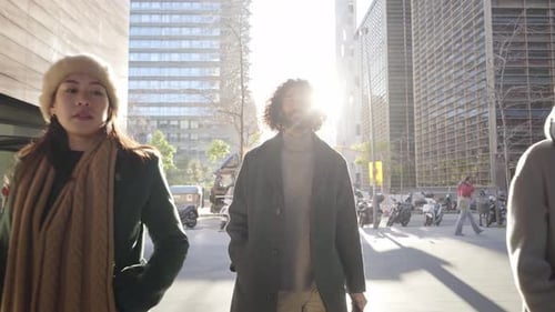 A Young Man Walks Confidently Towards the Camera and a Group of Business People Join Him Following