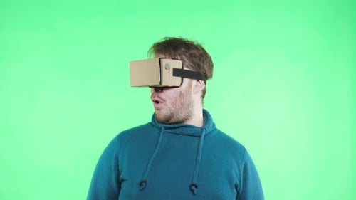 Funny man with vr glasses dances joyfully in chromakey greenbox studio