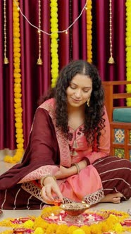 Woman Lights Diyas for Diwali Celebration at Home