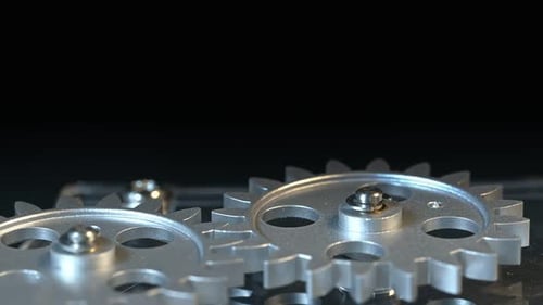 Rotating Silver Gears Against Black Backdrop